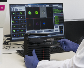 A man in a lab coat working on his computer.