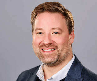  A man wearing a white shirt, and dark blazer